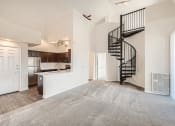 Thumbnail 4 of 20 - A Living Room and Kitchen with a Spiral Staircase at Fox Run Lofts Apartments