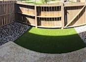 Thumbnail 8 of 17 - Newly renovated patio area with rocks and turf.