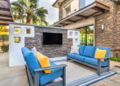 Thumbnail 4 of 46 - a living room with blue couches and a television at Metro Gateway, Riverside