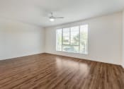 Thumbnail 29 of 46 - an empty living room with a window and wood flooring at Metro Gateway, Riverside, 92503