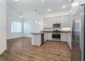 Thumbnail 17 of 46 - an empty kitchen with white cabinets and stainless steel appliances at Metro Gateway, Riverside, CA