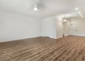 Thumbnail 27 of 46 - a living room with white walls and wood flooring and a ceiling fan at Metro Gateway, Riverside, 92503