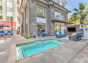 Thumbnail 2 of 46 - a swimming pool with chairs and a building with a fireplace at Metro Gateway, Riverside, CA, 92503