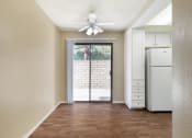 Thumbnail 12 of 22 - an empty living room with a white refrigerator and a ceiling fan