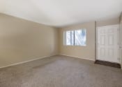 Thumbnail 14 of 22 - an empty living room with carpet and a white door