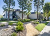 Thumbnail 17 of 22 - a house with a sidewalk and landscaping in front of it