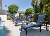 Thumbnail 4 of 22 - a group of lounge chairs on a patio next to a pool