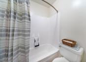 Thumbnail 17 of 29 - the bathroom has a shower curtain and a toilet and a sink