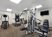 Thumbnail 7 of 29 - a gym with cardio equipment and a tv in a hotel room