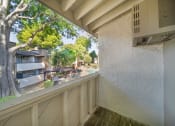 Thumbnail 26 of 29 - a balcony with a view of a tree and some buildings