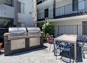 Thumbnail 3 of 21 - a patio with a grill and a table and chairs