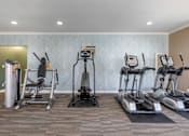 Thumbnail 13 of 28 - a gym with treadmills and elliptical machines at Sage Creek Apartment Homes, Simi Valley