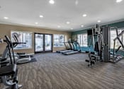 Thumbnail 11 of 28 - a gym with cardio equipment and windows at Sage Creek Apartment Homes, California