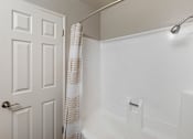 Thumbnail 22 of 28 - a bathroom with a white bathtub and a white door at Sage Creek Apartment Homes, California