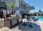 Thumbnail 2 of 21 - a barbecue and table with chairs in front of a swimming pool