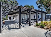 Thumbnail 7 of 28 - a patio with a pergola and tables and chairs at Sage Creek Apartment Homes, California, 93063
