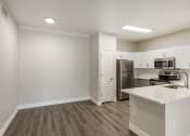 Thumbnail 22 of 42 - Modern kitchen with white cabinetry and stainless steel appliances at Trevi Apartment Homes, Chandler