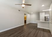 Thumbnail 23 of 42 - An airy living room beckons with a tranquil ceiling fan, while the kitchen beyond hints at culinary adventures at Trevi Apartment Homes, Arizona, 85224