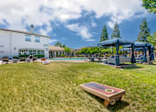 Thumbnail 9 of 50 - Next to our pool deck, a grassy area with cornhole boards invites friendly outdoor fun with neighbors.