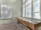 Thumbnail 17 of 33 - A black and white abstract painting hangs on a wall above a wooden table with a drawer.