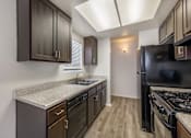 Thumbnail 10 of 21 - Sedona Apartments in Moreno Valley features renovated homes with modern flooring, updated cabinets, and stylish black appliances for a fresh, contemporary feel.