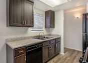 Thumbnail 12 of 21 - Sedona Apartments in Moreno Valley offers renovated units with sleek black appliances and modern chocolate-colored cabinets for stylish, comfortable living.
