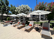 Thumbnail 10 of 32 - Enjoy our courtyard's lounge chairs and shaded umbrellas for a relaxing outdoor retreat at Boulders at Lookout Mountain Apartment Homes, Phoenix, AZ