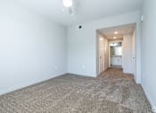 Thumbnail 35 of 46 - A long hallway with carpeted floors and white walls.