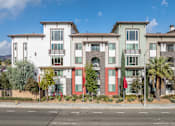Thumbnail 41 of 46 - A row of modern townhouses with red, white, and green exteriors.