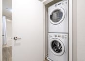 Thumbnail 15 of 46 - A white washing machine and dryer in a small laundry room.