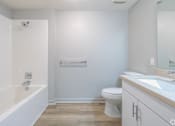 Thumbnail 24 of 46 - A white bathroom with a toilet, sink, and bathtub.