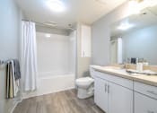 Thumbnail 23 of 46 - A white bathroom with a toilet, sink, and shower.