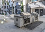 Thumbnail 6 of 46 - A modern outdoor kitchen with a grill and sink.