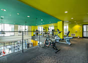Thumbnail 7 of 46 - A gym with a yellow wall and a treadmill.