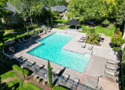 Thumbnail 18 of 28 - an aerial view of a swimming pool with chairs and umbrellas