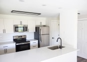 Thumbnail 14 of 28 - a kitchen with white countertops and a sink and a refrigerator