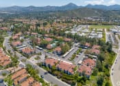 Thumbnail 44 of 48 - an aerial view of a neighborhood with houses and trees and mountains in the background at La Serena, San Diego