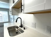 Thumbnail 3 of 18 - a kitchen with white cabinets and a sink