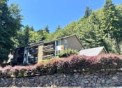 Thumbnail 12 of 18 - a view of a house with a stone wall and trees