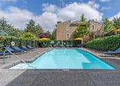 Thumbnail 10 of 12 - A large swimming pool surrounded by a black fence and lounge chairs.