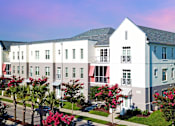 Thumbnail 18 of 33 - an aerial view of a row of white apartment buildings with red and blue awnings  at Link Apartments® Mixson, North Charleston, 29405