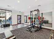 Thumbnail 19 of 33 - a gym with weights and dumbbells in the corner of a room at Link Apartments® Broad Ave, Tennessee