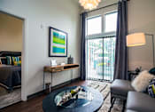 Thumbnail 14 of 37 - a living room with a large window and a sliding glass door at Link Apartments® Canvas, Georgia, 30312