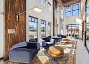 Thumbnail 7 of 33 - a lobby with blue chairs and tables and windows at Link Apartments® Broad Ave, Memphis, 38112