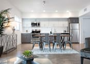 Thumbnail 15 of 28 - A modern kitchen with a dining table set for six.
