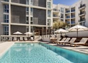 Thumbnail 1 of 28 - A large swimming pool in front of a modern building.