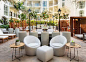 Thumbnail 7 of 28 - A patio with white chairs and tables.