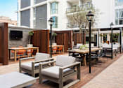 Thumbnail 18 of 28 - A patio with a table and chairs is surrounded by buildings.