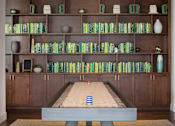 Thumbnail 17 of 28 - A shelf with books and vases on it.