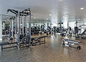 Thumbnail 9 of 28 - A gym with a variety of equipment including a leg press machine.